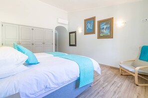 A bedroom with a bed, a chair, and two framed pictures on the wall. - Villa Dean Private Pool Family Golf Escape (Lagos)