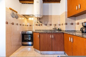 A compact kitchen with a built-in oven, a sink, and wooden cabinets. - Casa Saudade Pet Friendly Terrace Ferragudo (Lagoa)