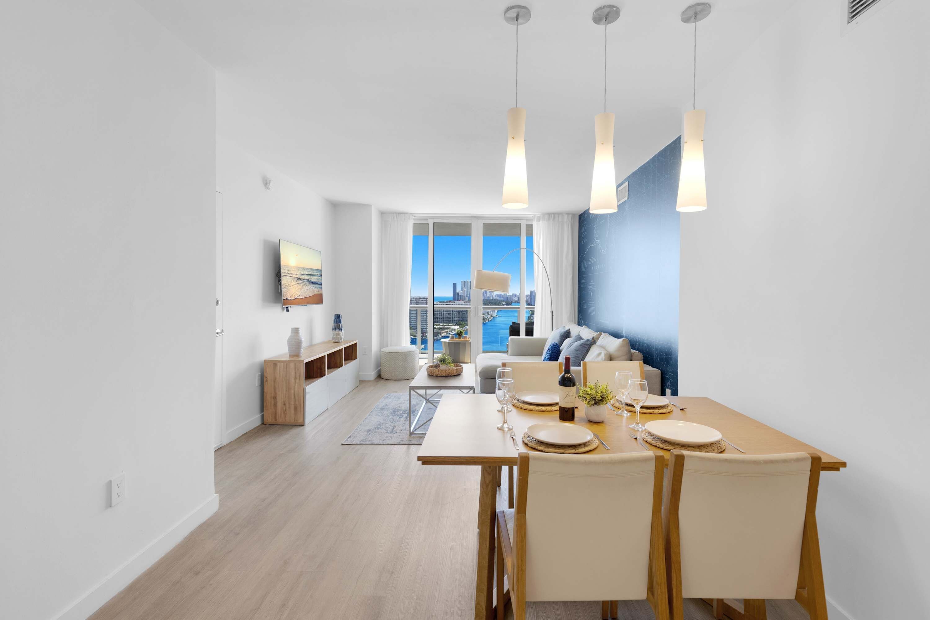 A modern dining area with a view of the city skyline, a large window, and a blue accent wall.