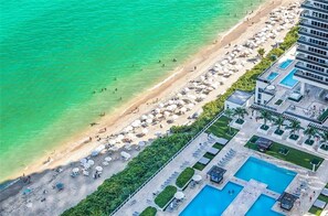 A resort with a beach, pool area, and a building with balconies. - 2BR Ocean View Balcony Pool (Hollywood)