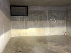 A room with a concrete floor, a window with a metal screen, and wall markings with numbers. - Apartment with 2 large balconies, mountain view (Cohennoz)