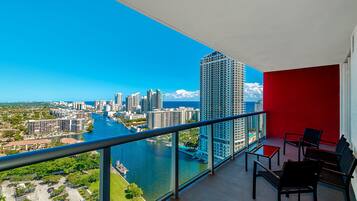 A balcony with a city view overlooking a river and high-rise buildings.