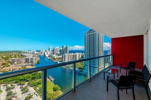 Un balcón con vista a la ciudad, sobre un río y edificios altos.