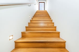 Una escalera de madera que conduce a una puerta en la parte superior.