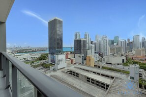 A high-rise building with a view of a cityscape, including other tall buildings and a marina. - 1BR Apartment With Pool gym and Balcony (Miami)