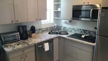 A modern kitchen with stainless steel appliances, a microwave, a toaster, and a coffee maker.