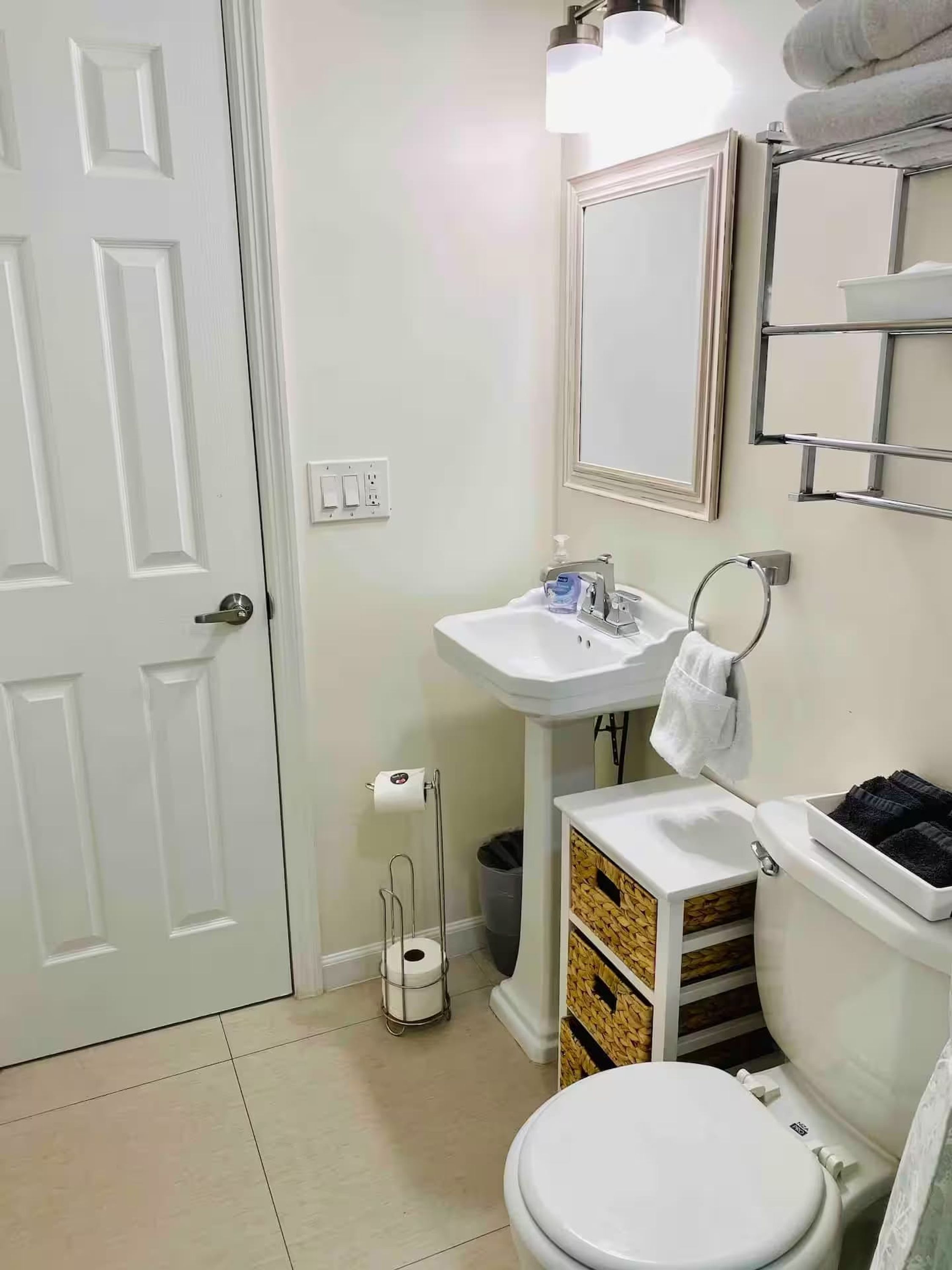 Une salle de bain équipée de toilettes, d’un lavabo et d’un porte-serviettes.