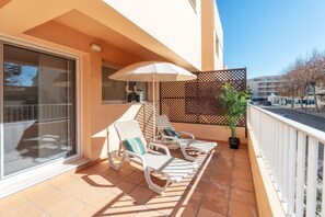 A balcony with two lounge chairs, a potted plant, and a decorative fence. - BnB Homes Duplex Apartment With 2 Bedrooms (Lagoa)
