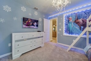 A child's bedroom with a bunk bed, a dresser, a chandelier, and wall decorations including snowflakes and a movie poster. - Spacious 10-bedroom Home Ideal for Large Families Groups With Private Pool (Davenport)