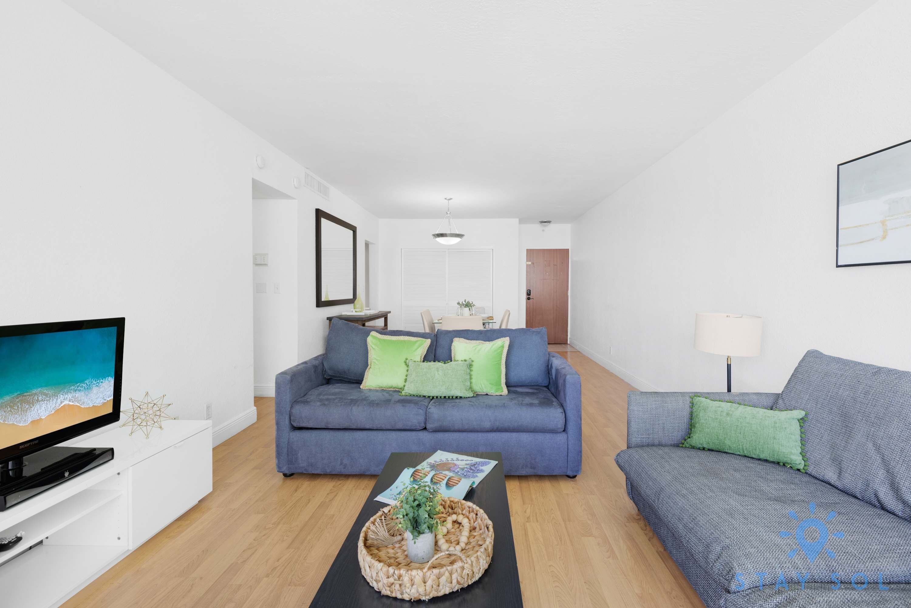Ein Wohnzimmer mit einer Couch, einem Couchtisch und einem Fernseher.