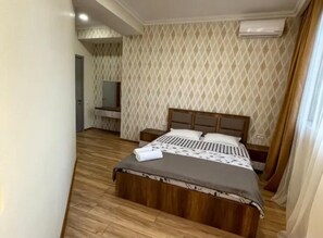 A hotel room with a wooden bed, a patterned wall, and an air conditioning unit. - GREAT APARTMENT IN THE CENTER OF TBILISI (T'bilisi)