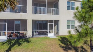 A multi-story building with large windows, a balcony, and outdoor seating. - Stylish 3-bedroom Townhouse in Champions Gate Sleeps 12 Resort Amenities (Almont)