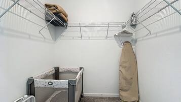 A laundry room with a drying rack, a drying machine, and a storage bin.
