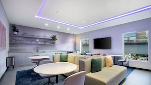 Uma sala de estar moderna com sofá, mesa de jantar e área de cozinha com prateleiras.