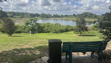 Un parco con una panchina, un piccolo deposito e un lago sullo sfondo.