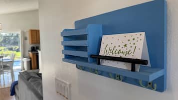 A blue wall-mounted rack with a 'Welcome!' sign and a card with stars.