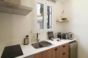 A modern kitchen with a built-in stove, a sink, and a window above the counter. - Villa Lara Seafront in Polis (Pachyammos)