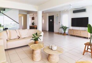 Ein modernes Wohnzimmer mit einer Couch, einem Couchtisch und einem Fernseher.