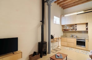 Una cocina moderna con armarios de madera, horno integrado y cafetera.