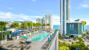 A hotel with a swimming pool, lounge chairs, and palm trees. - Oceanfront Escape With Resort-style Amenities (Hollywood)