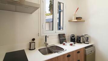 Una cocina moderna con estufa integrada, un lavamanos y un ventanal sobre la encimera.