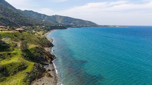 A coastal landscape with a clear view of the sea, a rocky shoreline, and a mountainous backdrop. - Villa Paradise in Polis (Pachyammos)