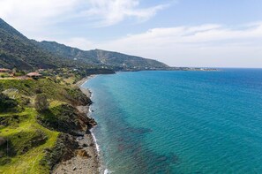 A coastal landscape with a clear view of the sea, a rocky shoreline, and a mountainous backdrop. - Villa Paradise in Polis (Pachyammos)