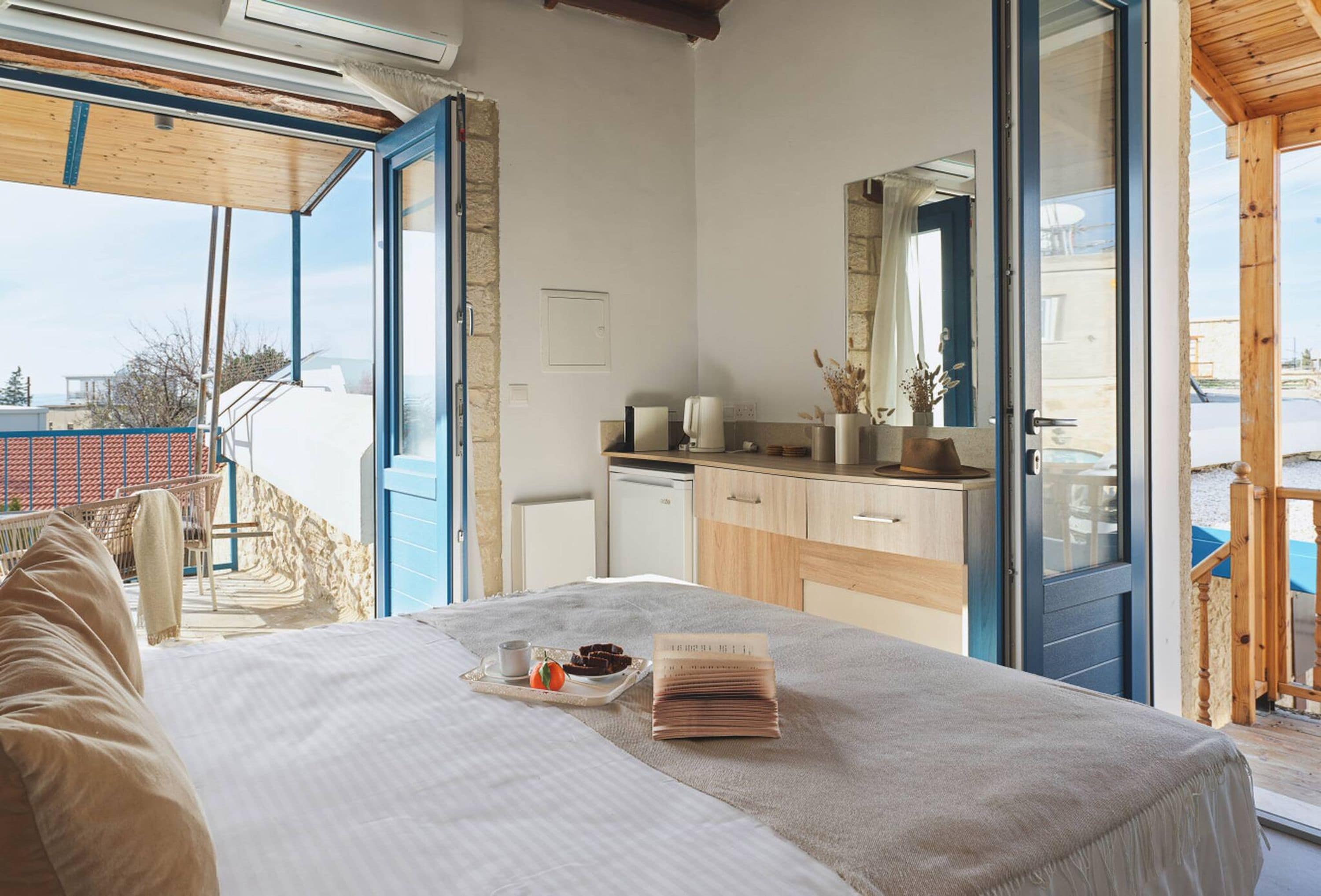 Un dormitorio con cama, mesita de noche, escritorio pequeño y ventana.