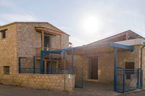 A stone building with a balcony and a covered entrance. - Maisonette at The Olive Manor (Peristerona)