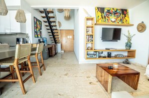 Ein moderner Wohnraum mit Küche, Essbereich und einer Treppe.