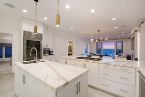 A modern kitchen with a central island, stainless steel appliances, and a view of the ocean. - Casa de Malibu in Malibu (Malibu)