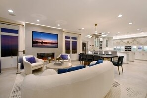 A modern living room with a fireplace, a dining area, and a kitchen. - Casa de Malibu in Malibu (Malibu)