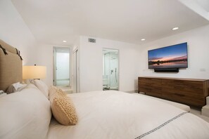 A hotel room with a large bed, a TV mounted on the wall, and a wooden dresser. - Casa de Malibu in Malibu (Malibu)