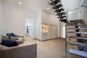 A modern interior with a staircase, a seating area, and a kitchen. - Casa de Malibu in Malibu (Malibu)