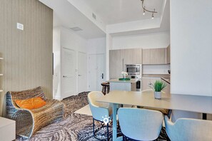 A modern apartment with a dining area, kitchenette, and a cozy seating area with a patterned rug. - Cozy Apartment -balcony Beachfront Resort (Hollywood)