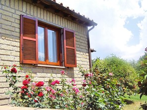A brick house with two windows, each with wooden shutters. - Montecasciano Mimosa (Capranica)