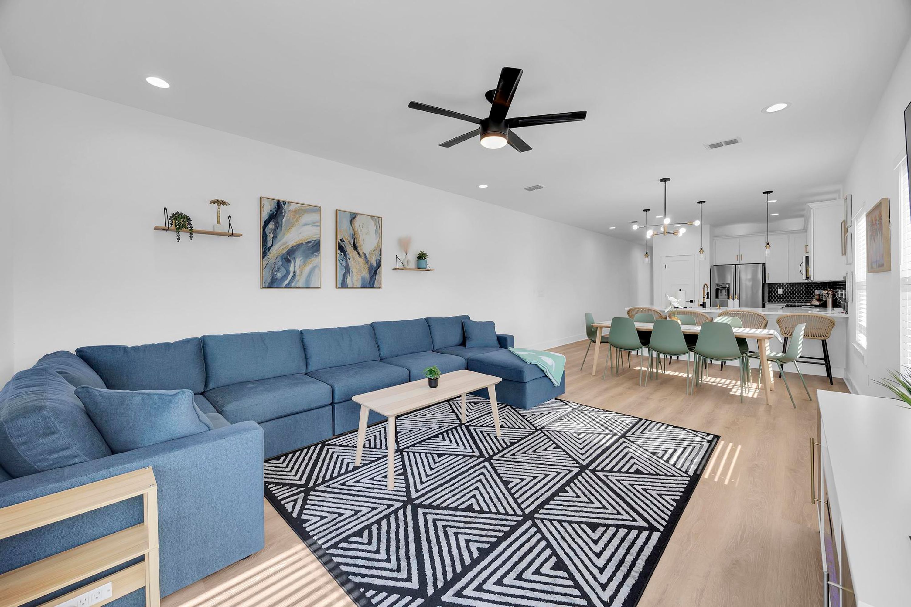 A modern living room with a blue sofa, a coffee table, and a geometric rug.