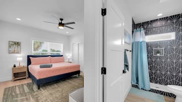 A modern bedroom with a bed, bedside table, and a ceiling fan.