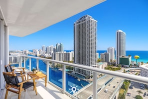 Un balcon offrant une vue sur le paysage urbain et l’océan.