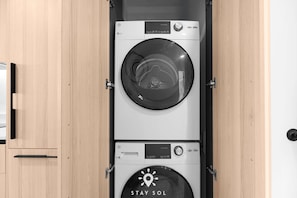 A compact, wall-mounted washer and dryer unit with a control panel and a 'STAY SOL' logo. - 2BR Corner View With Free Parking (Miami)