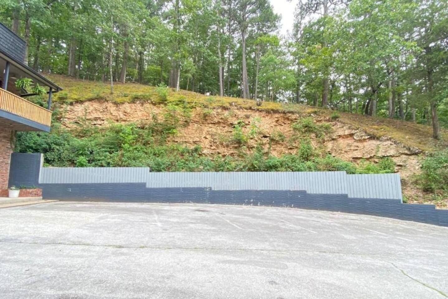 A building with a concrete patio and a retaining wall.