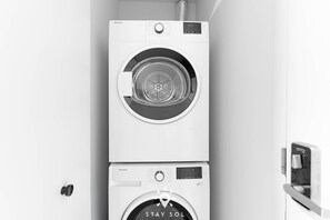 A wall-mounted, stacked washer and dryer unit with a control panel and a digital display. - Elite Stay With Rooftop Vibes Studio (Miami)