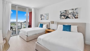 Ein Hotelzimmer mit zwei Betten, einem Schreibtisch und einem Sessel.