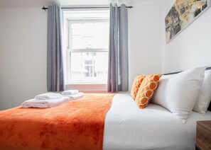 A hotel room with a bed, a window with curtains, and a view of the outside. - Portobello Executive Residence - Free Wifi (London)