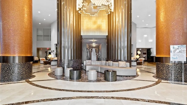 A spacious lobby with a central seating area, a chandelier, and a reception desk. - Oceanview Studio Pool Beach Dining Miami (Sunny Isles Beach)