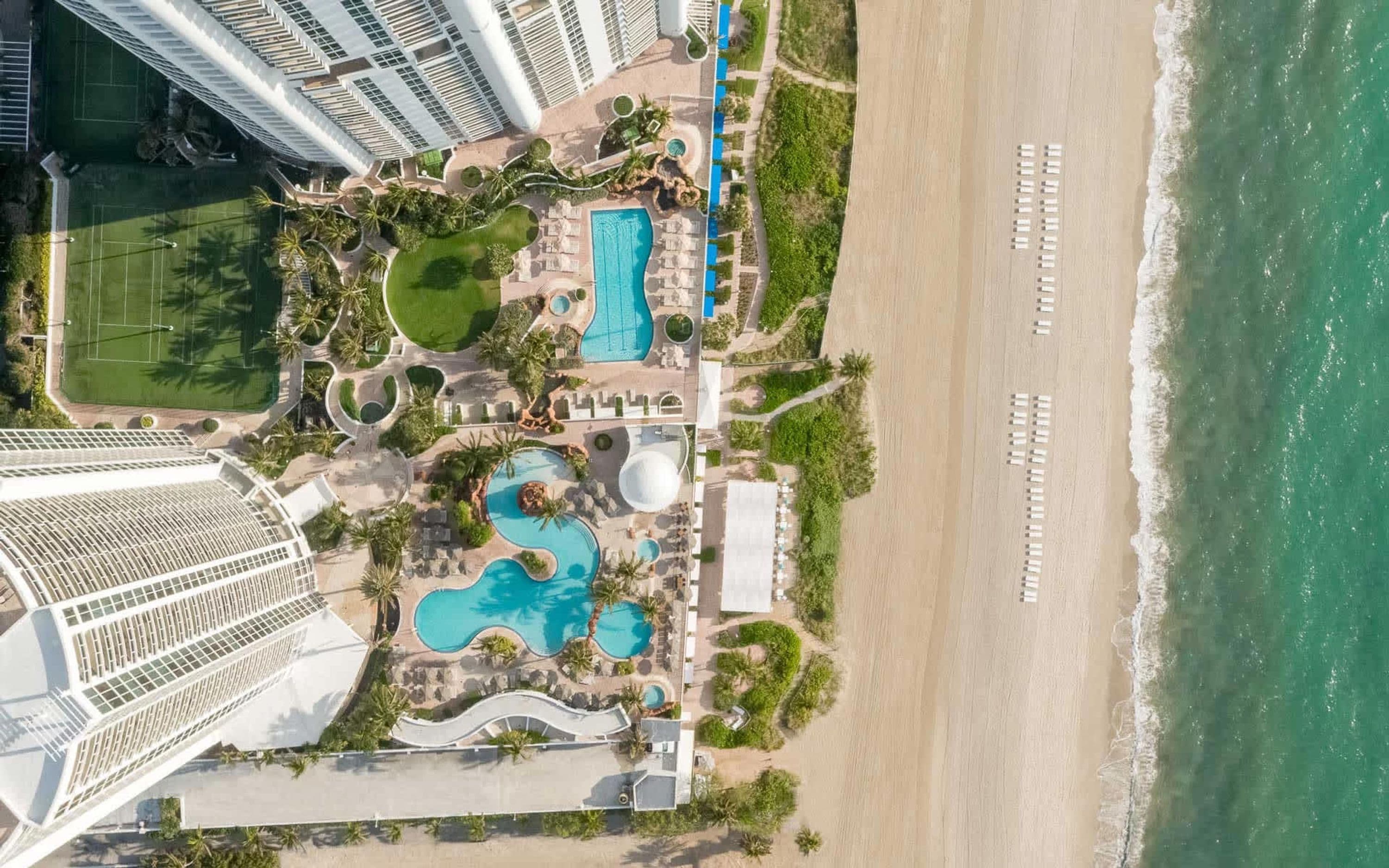 Un complexe hôtelier doté de plusieurs piscines, d’une plage et d’immeubles de grande hauteur.