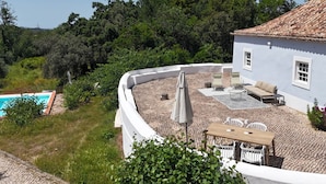 Una casa con piscina, mobiliario de exterior y jardín.