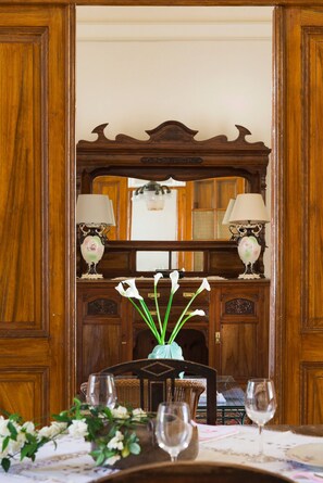 A dining area with a wooden table set for two, flanked by two lamps with floral designs. - Place of Grace in Lefkara (Pano Lefkara)