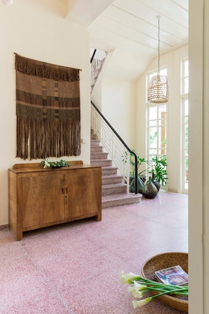A staircase with a railing, a wooden console table with a plant, and a woven tapestry on the wall. - Place of Grace in Lefkara (Pano Lefkara)