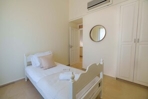 Ein Schlafzimmer mit einem Bett, einem runden Spiegel und einem Kleiderschrank.